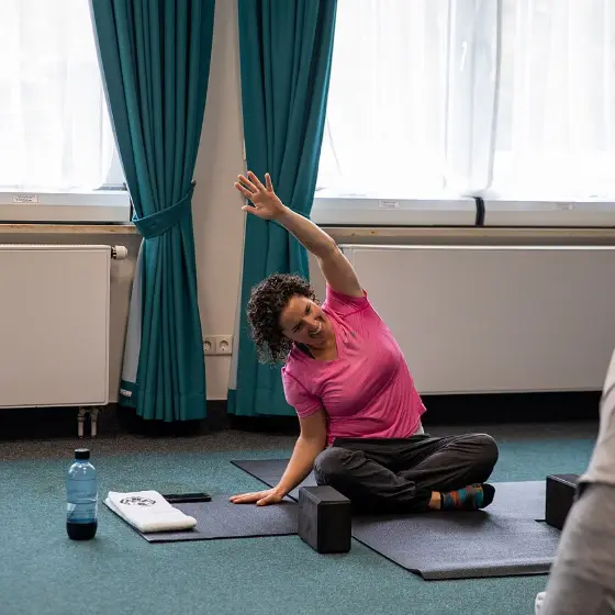 Mulher a alongar numa aula de yoga